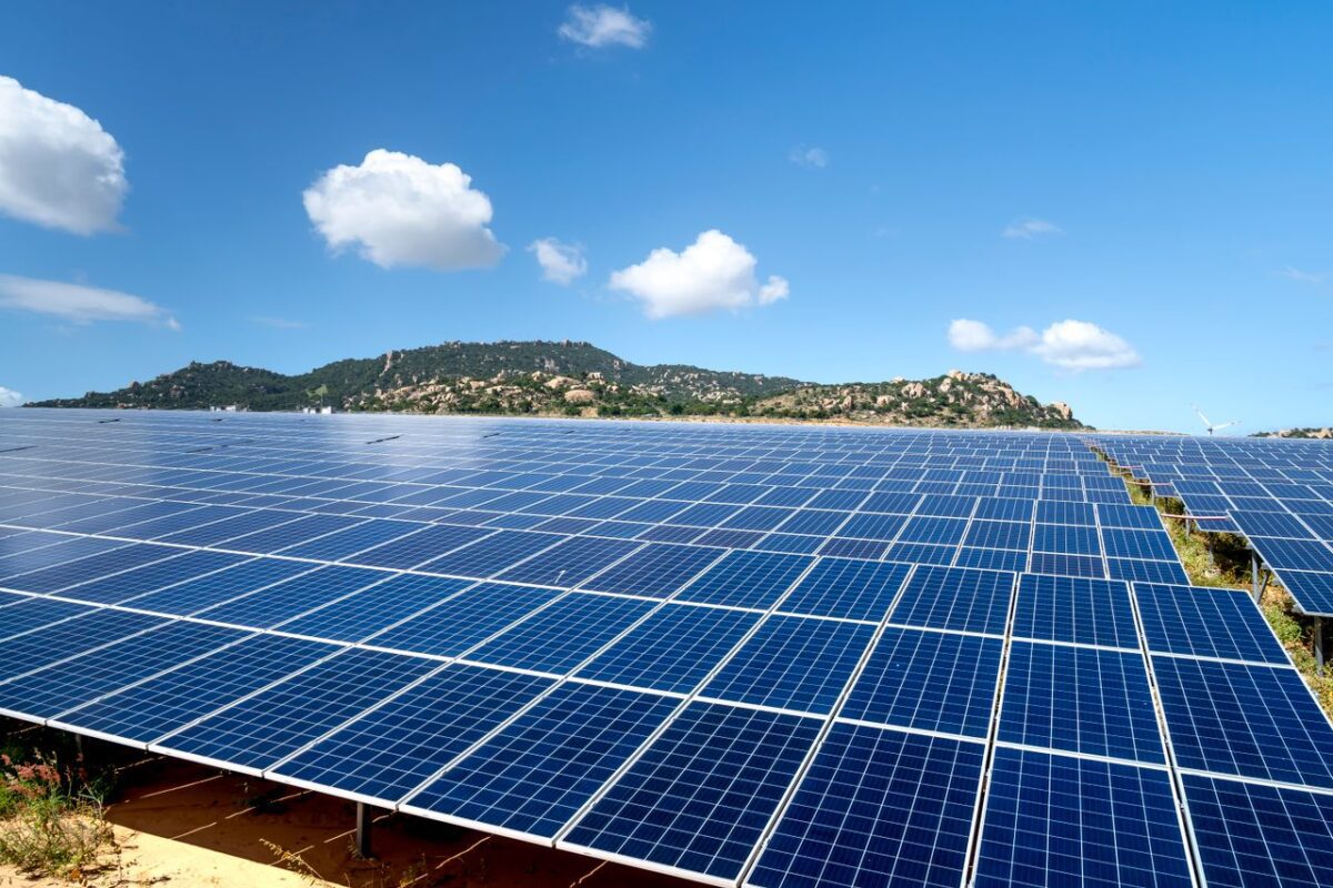 Paneles solares en un campo verde bajo un cielo azul