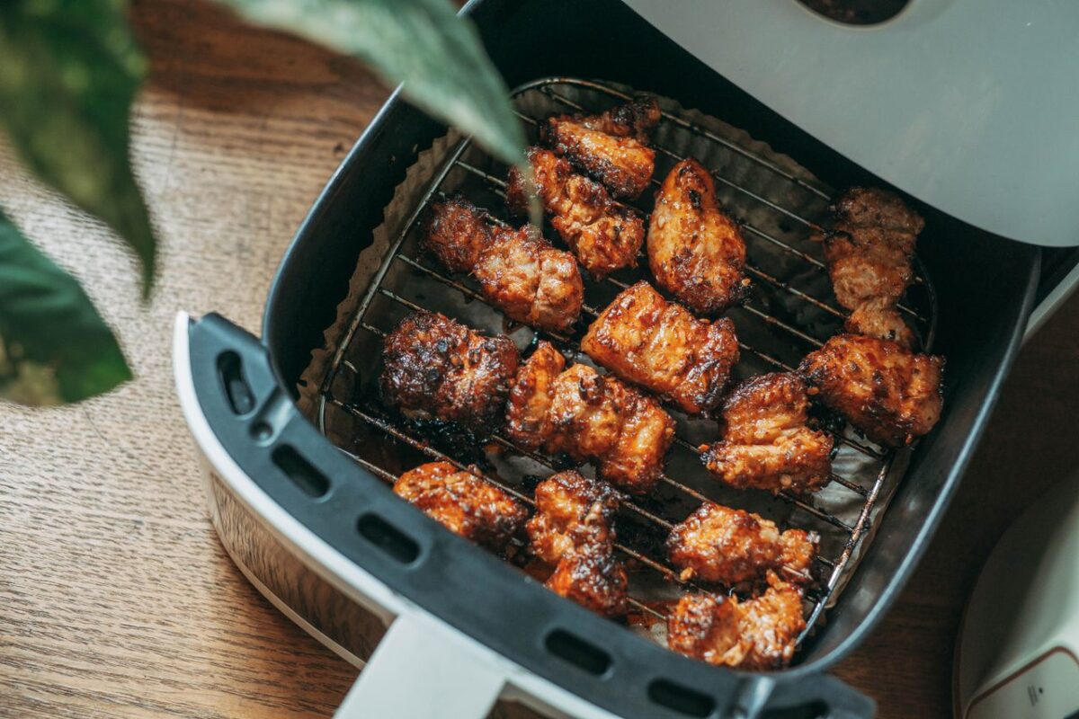 Freidora de aire con pollo crujiente recien cocinado